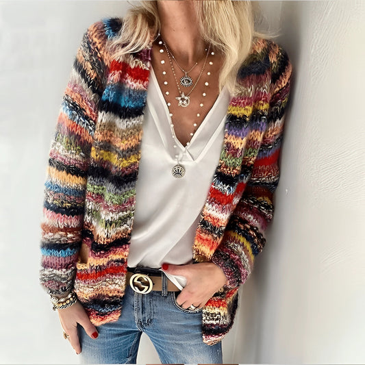 Multicolor chunky knit cardigan in boho wool, worn by a person with jeans, showcasing cozy sustainable fashion with long sleeves and a collar.