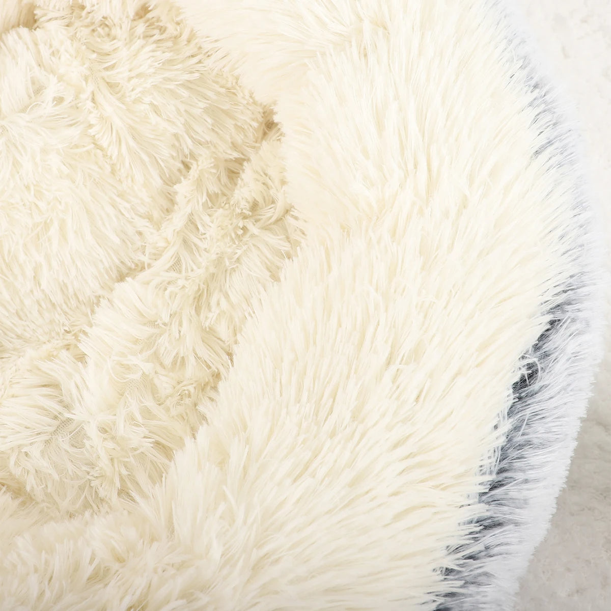 "Cozy plush donut dog bed with deep sides, faux fur, circular shape for comfort and anxiety relief in various sizes."