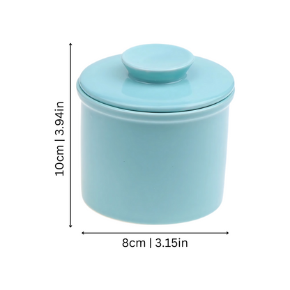 "Elegant ceramic butter keeper with water-sealed system in sleek black, light blue, and white, perfect for kitchen décor."