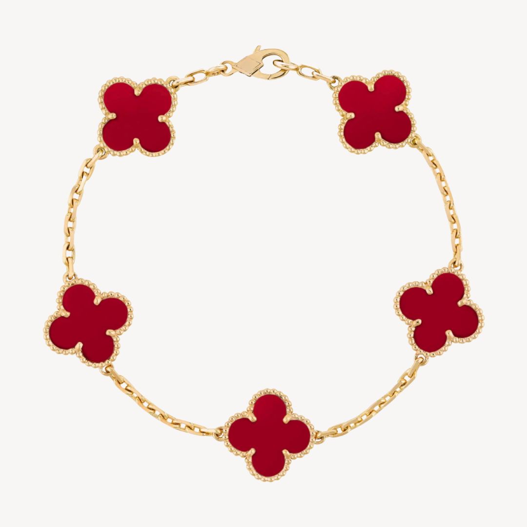 Elegant clover charm bracelet with polished black agate inlays and a gold and silver-tone chain for sophisticated style.