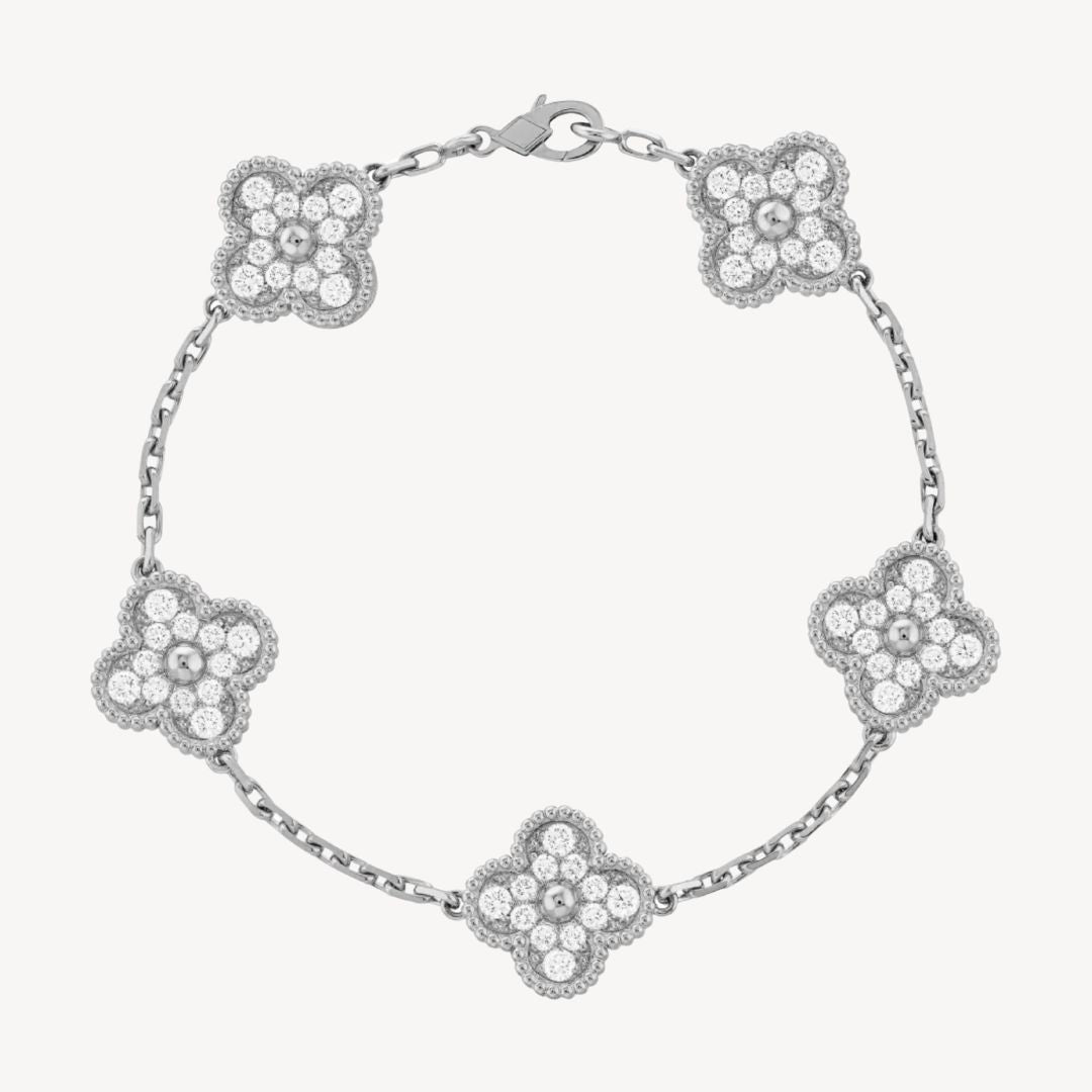 Elegant clover charm bracelet with polished black agate inlays and a gold and silver-tone chain for sophisticated style.