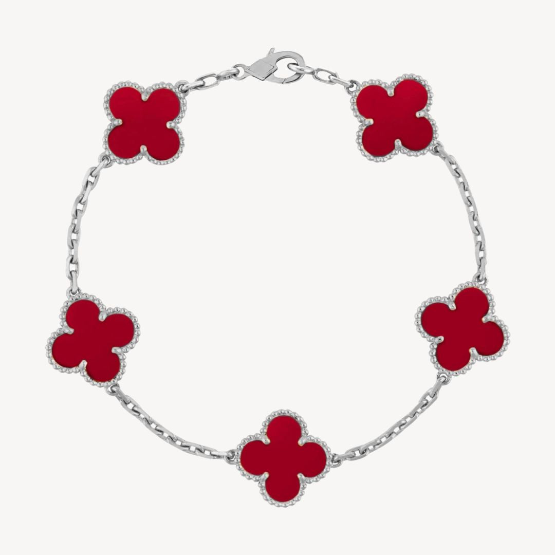 Elegant clover charm bracelet with polished black agate inlays and a gold and silver-tone chain for sophisticated style.