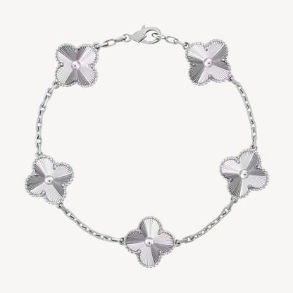 Elegant clover charm bracelet with polished black agate inlays and a gold and silver-tone chain for sophisticated style.