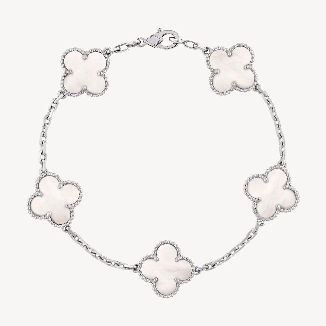 Elegant clover charm bracelet with polished black agate inlays and a gold and silver-tone chain for sophisticated style.