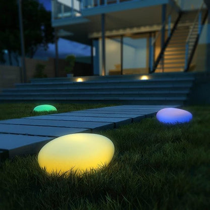 Elegant LED garden light with cobblestone design, glowing in multiple colors, ideal for illuminating outdoor spaces like gard