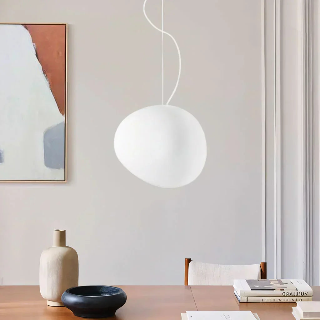 Elegant white pebble pendant light; minimal design, frosted glass, metal accents, soft glow for modern interiors.