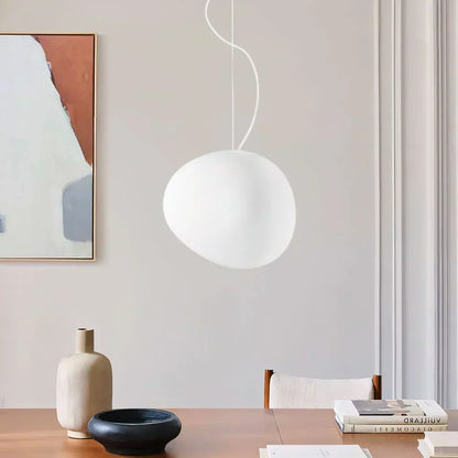 Elegant white pebble pendant light; minimal design, frosted glass, metal accents, soft glow for modern interiors.