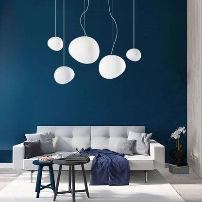 Elegant white pebble pendant light; minimal design, frosted glass, metal accents, soft glow for modern interiors.