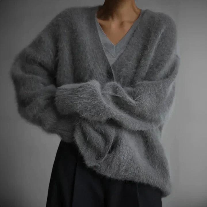 "Elegant women's cashmere cardigan in soft grey, showcasing a luxurious knit texture for ultimate softness and comfort."
