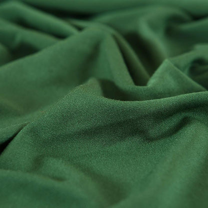 "Emerald green sofa cover on a couch, showcasing its stretchy and durable fabric, perfect for protection and style."