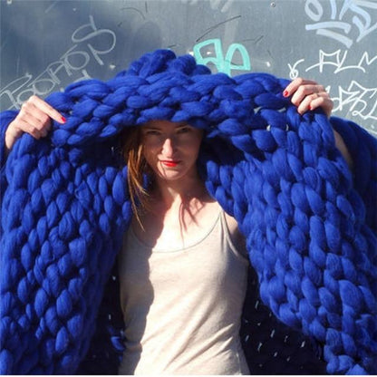 "Handmade chunky knit blanket, super soft texture, vibrant colors draped on furniture, decorative and cozy home accent."