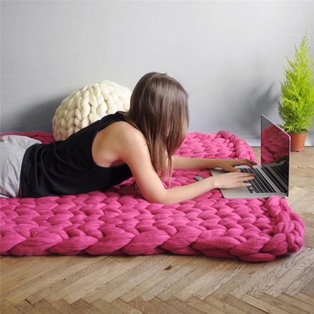 "Handmade chunky knit blanket, super soft texture, vibrant colors draped on furniture, decorative and cozy home accent."