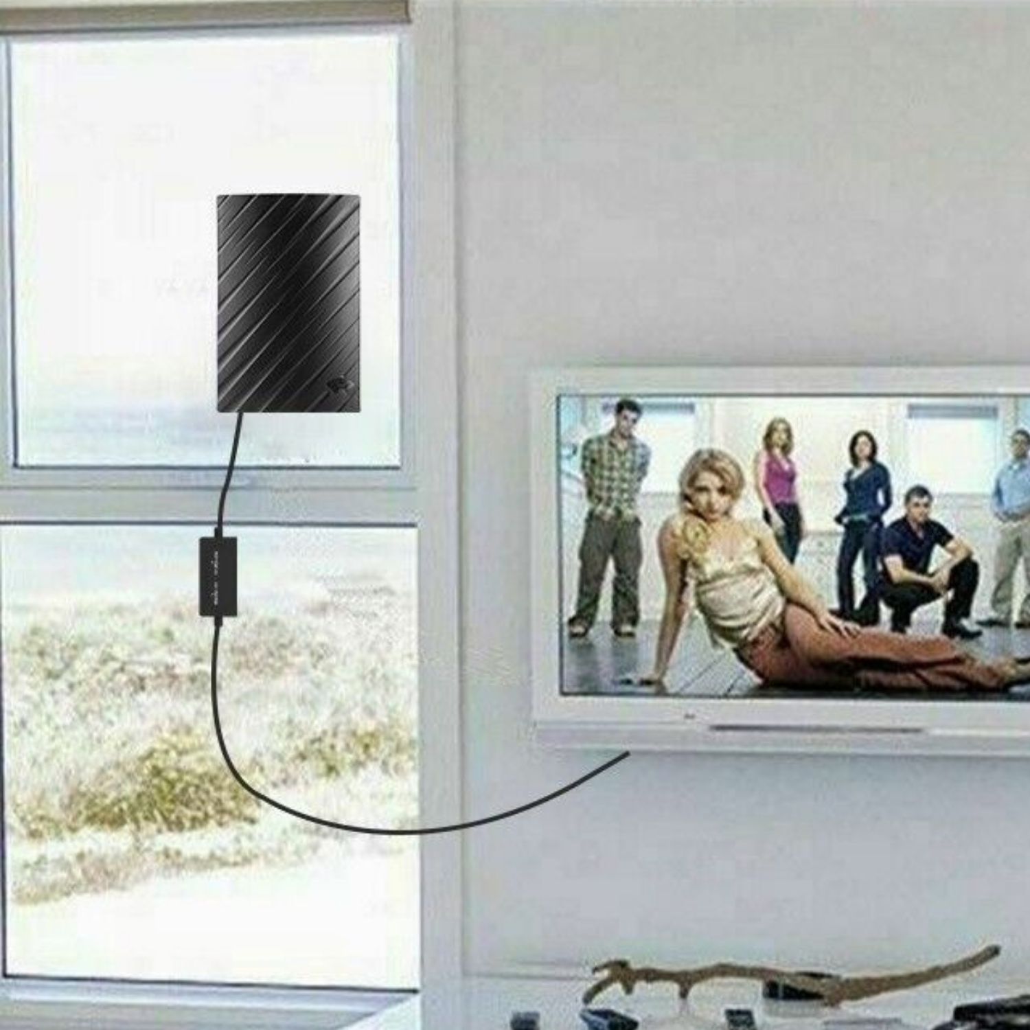 "Indoor 4K HDTV antenna, sleek black design, up to 600 miles range, with coaxial cable, fits modern living spaces."