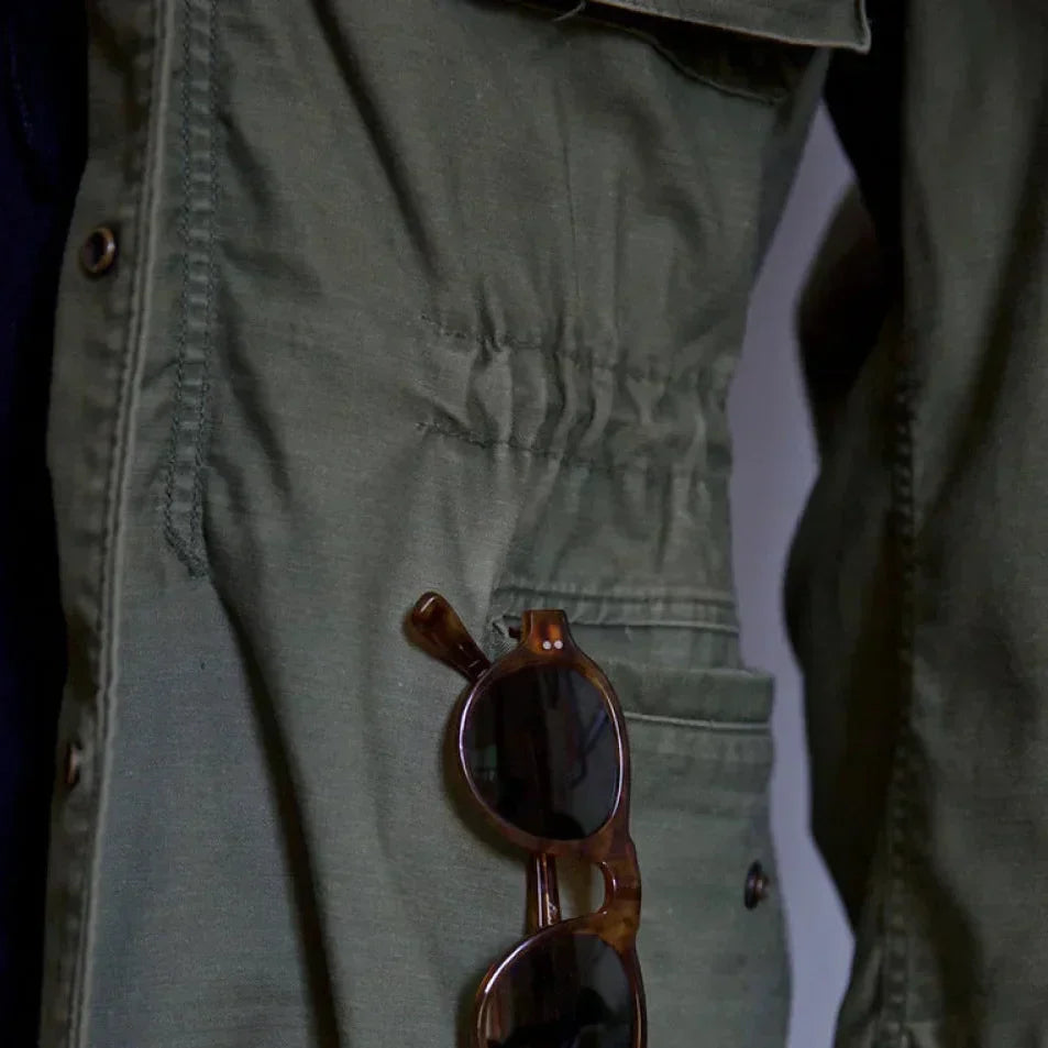 Men's vintage cotton field jacket with adjustable waist, rugged design, breathable fabric, suitable for layering.
