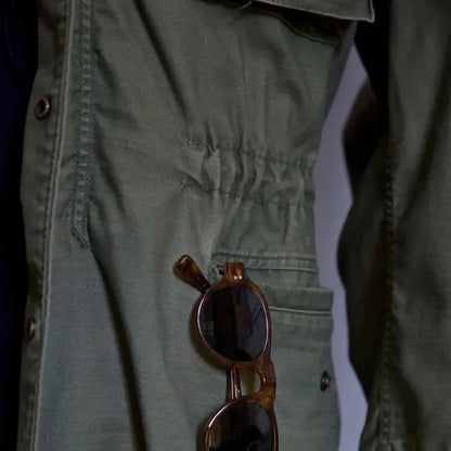 Men's vintage cotton field jacket with adjustable waist, rugged design, breathable fabric, suitable for layering.