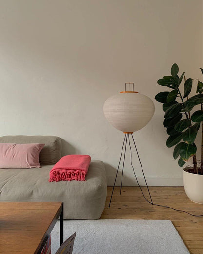 "Minimalist rice paper floor lamp with sleek metal frame and soft diffused light, perfect for creating a warm ambiance."