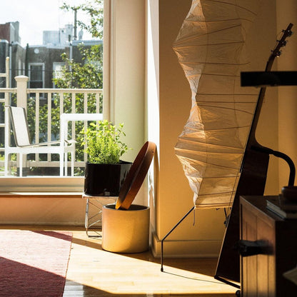"Minimalist rice paper floor lamp with sleek metal frame and soft diffused light, perfect for creating a warm ambiance."