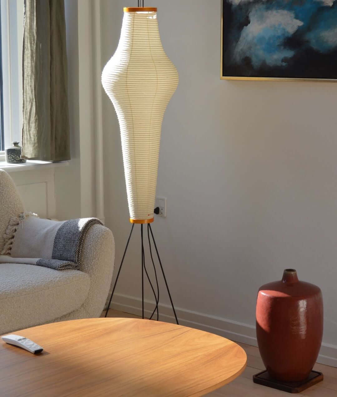 "Minimalist rice paper floor lamp with sleek metal frame and soft diffused light, perfect for creating a warm ambiance."