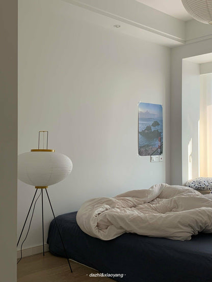 "Minimalist rice paper floor lamp with sleek metal frame and soft diffused light, perfect for creating a warm ambiance."