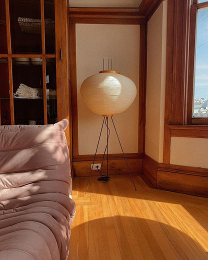 "Minimalist rice paper floor lamp with sleek metal frame and soft diffused light, perfect for creating a warm ambiance."