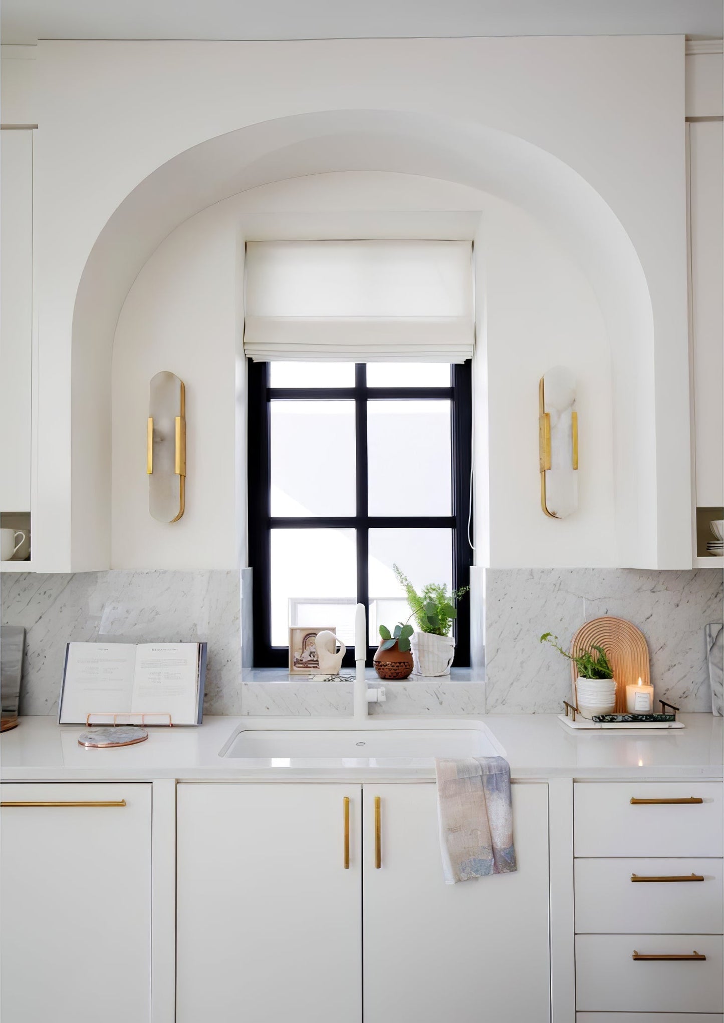 "Modern elongated alabaster wall lamp with metal and brass accents, emits warm glow, suitable for chic interior decor."