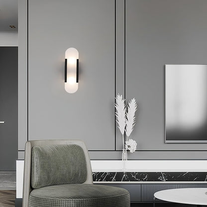 "Modern elongated alabaster wall lamp with metal and brass accents, emits warm glow, suitable for chic interior decor."