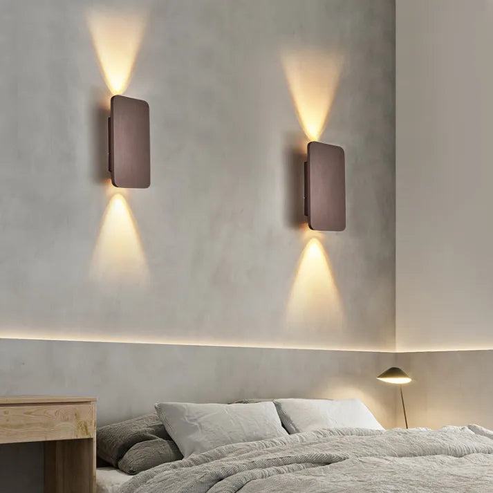 "Sleek indoor LED wall lamp with a modern rectangular design, featuring smooth finishes and warm illumination for elegant dec