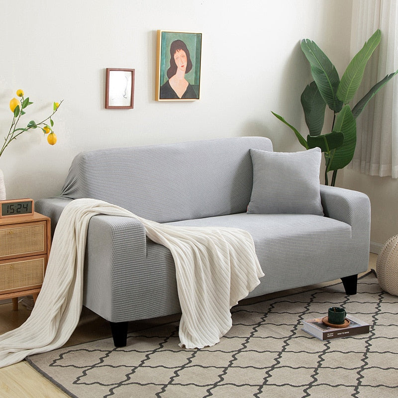 "Textured stretch sofa cover in beige, snug fit for sofas, non-slip, adds elegance, protects against spills and wear."