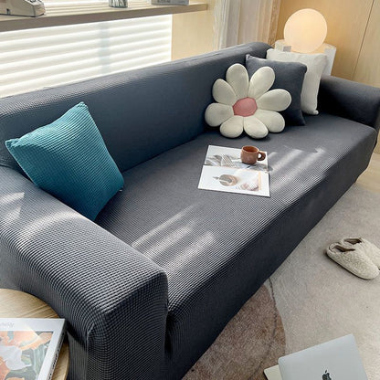 "Textured stretch sofa cover in beige, snug fit for sofas, non-slip, adds elegance, protects against spills and wear."