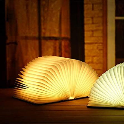 "Whimsical LED book lamp with warm glow, resembling an open book, perfect for cozy decor in bedrooms or study areas."