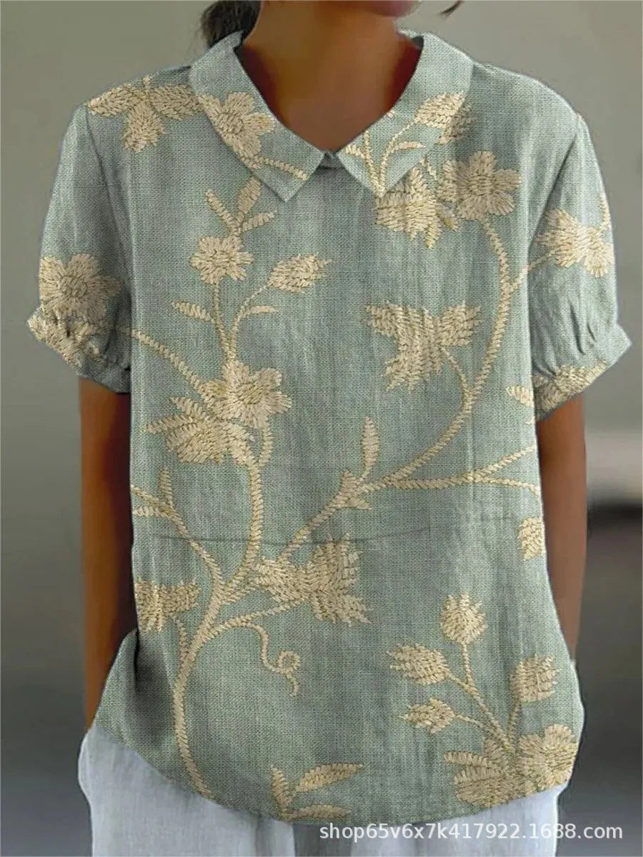 Women's elegant floral blouse with short sleeves and Peter Pan collar, featuring a vibrant floral pattern for stylish summer 