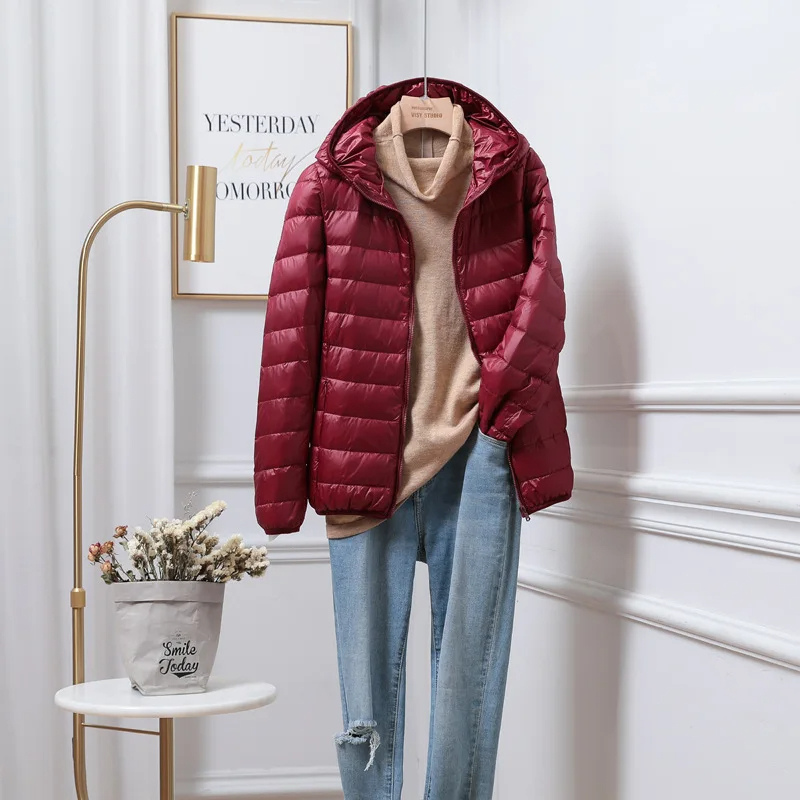 "Women's ultralight foldable puffer jacket with hood, chic design, lightweight, perfect for travel and cold weather."