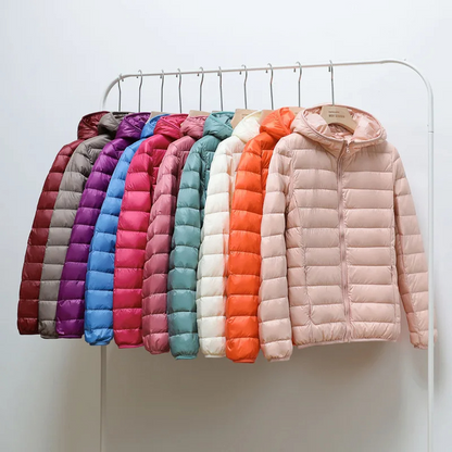"Women's ultralight foldable puffer jacket with hood, chic design, lightweight, perfect for travel and cold weather."