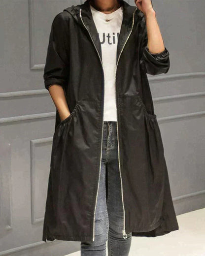 Women's waterproof hooded jacket in knee-length, relaxed fit, shown in lightweight fabric with ruched pockets for stylish cov