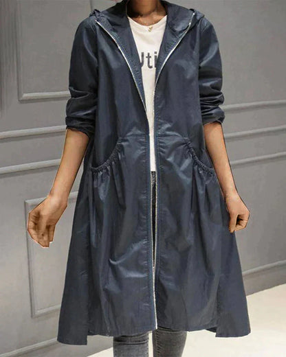 Women's waterproof hooded jacket in knee-length, relaxed fit, shown in lightweight fabric with ruched pockets for stylish cov