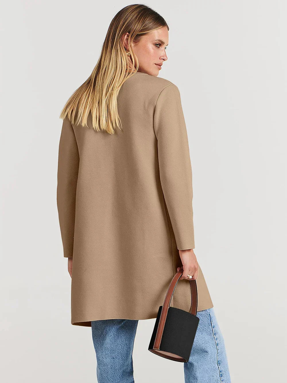 "Women's wool blend knee-length coat with wide lapel and patch pockets, showcasing a relaxed fit and minimalist design."